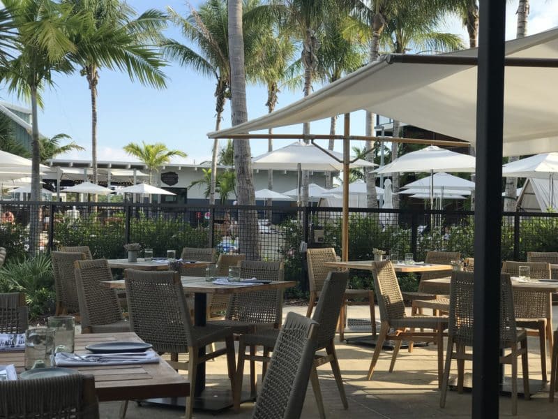 Outdoor dining at Matts Stock Island Kitchen overlooks the water, and is shaded by market umbrellas. A great dog-friendly restaurant