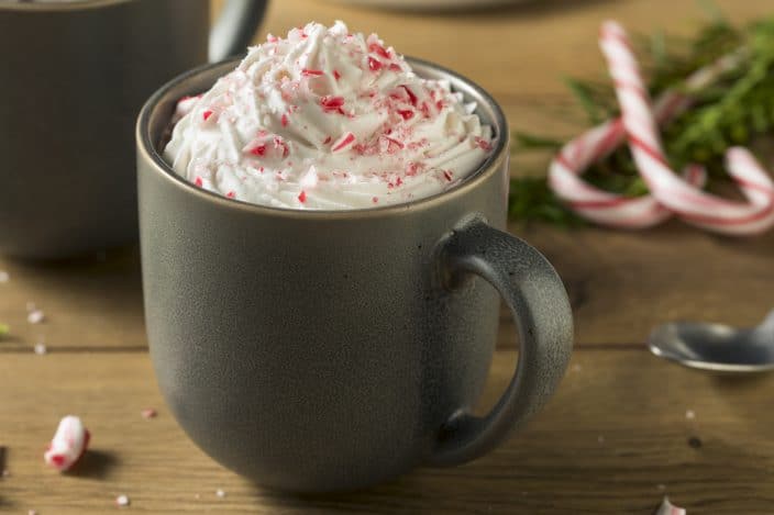 spiked hot chocolate candy cane topped with whipped cream