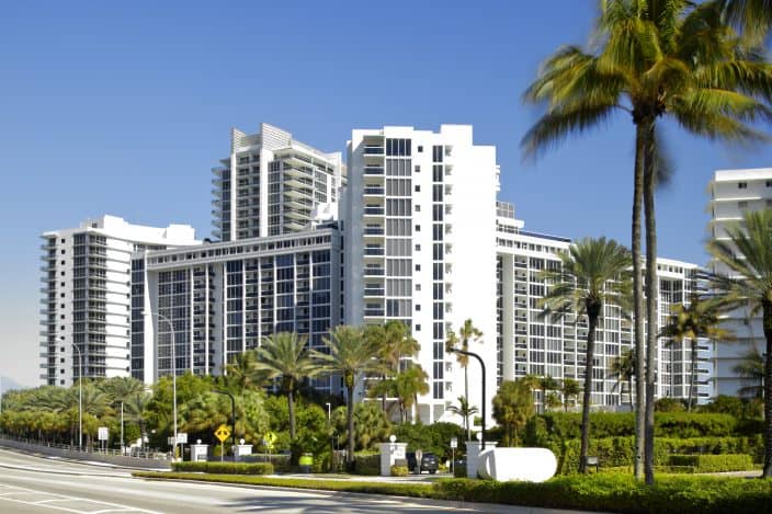Bal Harbour high rises in Miami with blue skies and palm trees