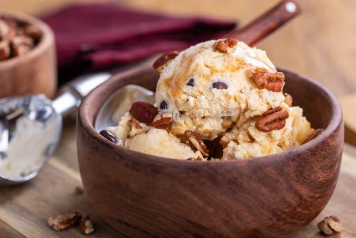 no churn salted caramel and pecan ice cream in a wooden bowl with a spoon