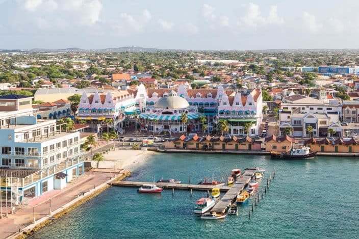 Colorful buildings in Oranjestad, Aruba with a view of the sea and mountains in the background
