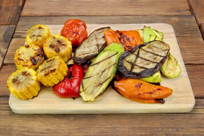 Grilled Vegetables On The Wood Cutting Board featuring Tomato, Bell Pepper, Zucchini, Eggplant, Sweet Corn Rings