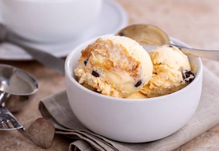 No Churn Salted Caramel Ice Cream In White Bowl with pecans and a spoon