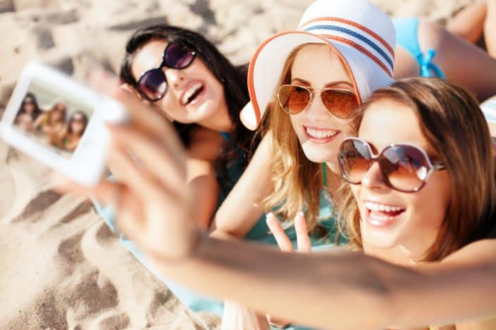 Group of girls taking a selfie on the beach during their beach day.