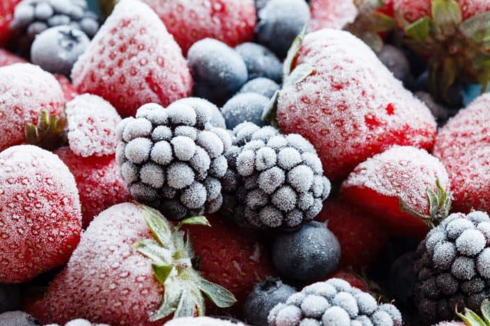 a close up of frozen blackberries, strawberries, and blueberries 