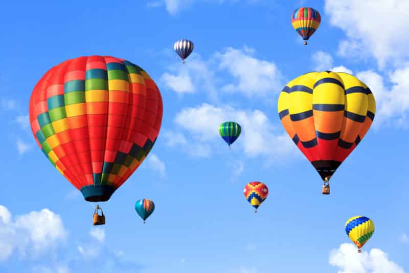 colorful hot air ballon in a cloud filled blue sky