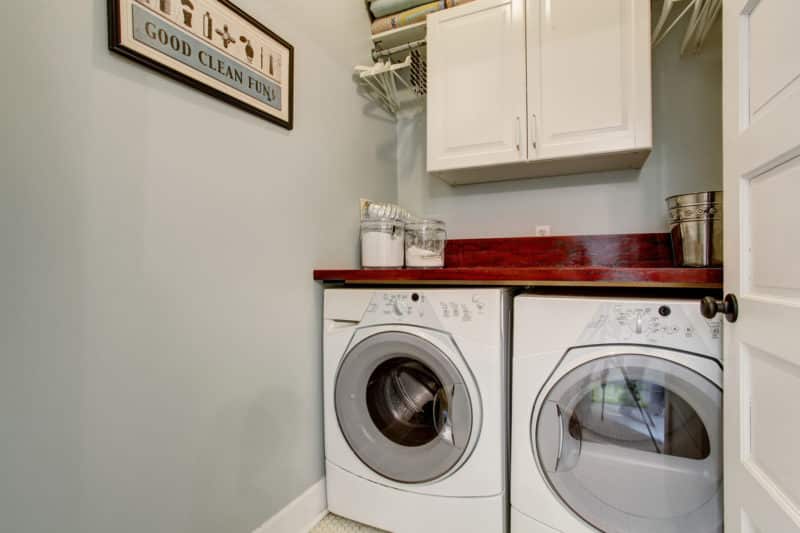 Small laudnry room with tile floor, door, and washer dryer set.