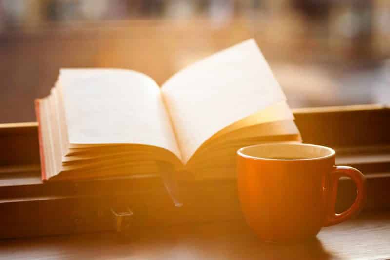 book with cup of coffee on a windowsill