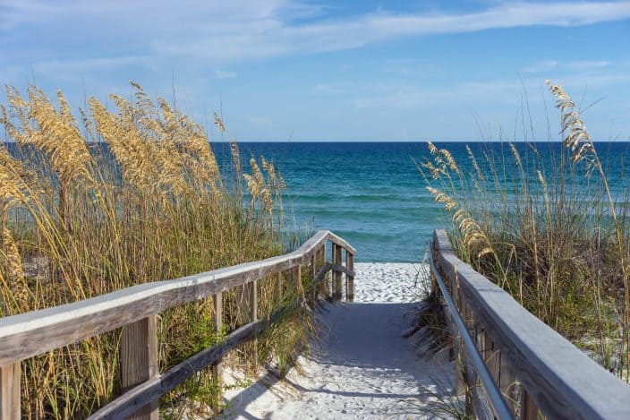 Sandy boardwalk path to a snow white beach on the Gulf of Mexico with ripe sea oats, the perfect location for a romantic spa weekend getaway