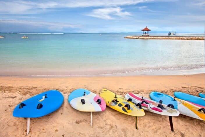 Surf boards on idyllic tropical sand Nusa Dua beach, Bali. An example of an activity you can do during a romantic adventure getaway