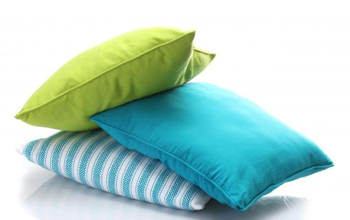 a bright, lime green, bright blue, and blue and white striped pillows on a white background